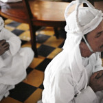 Cao Dai men pray Men in prayer at the CaoDai temple in Tay Ninh, Vietnam